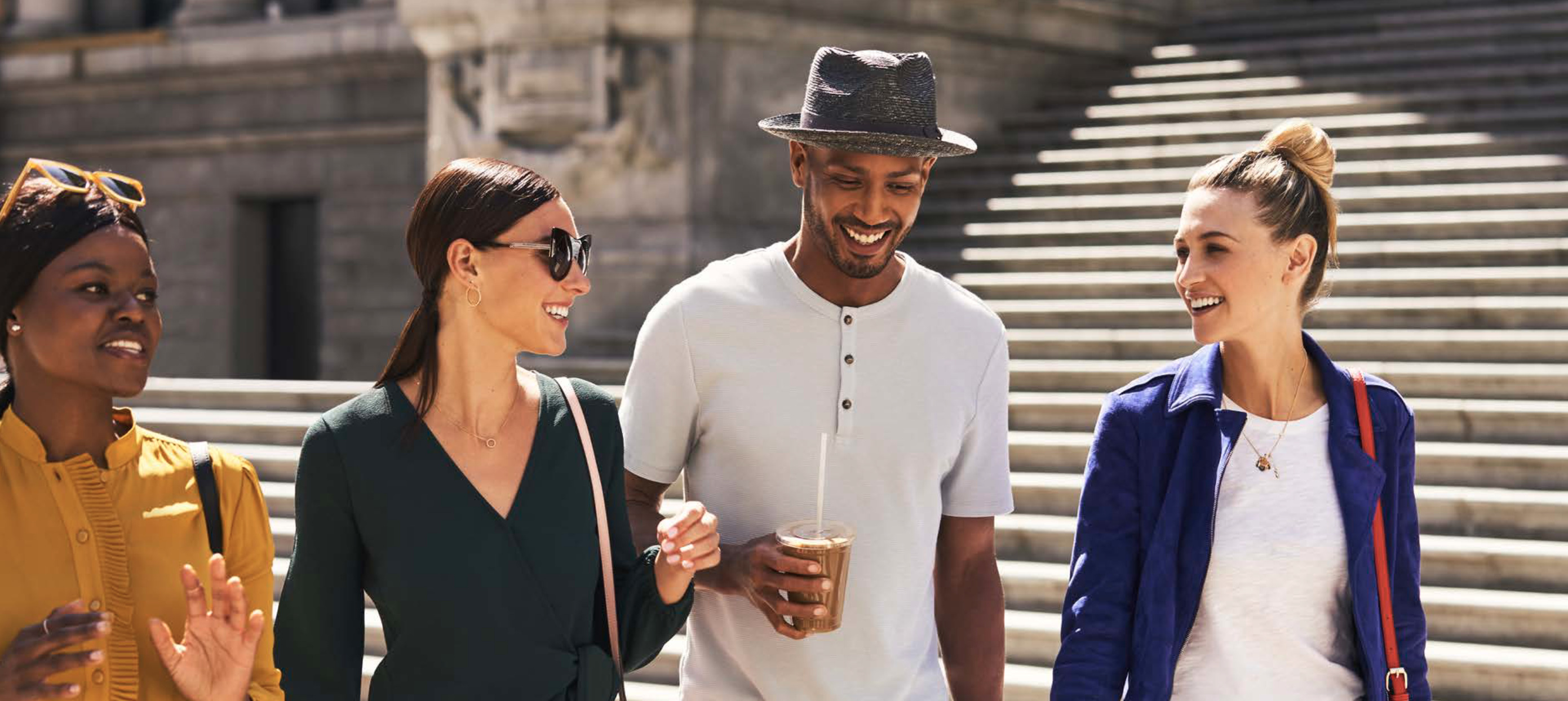 Guests walking through New York with coffee near Tribeca Terrace